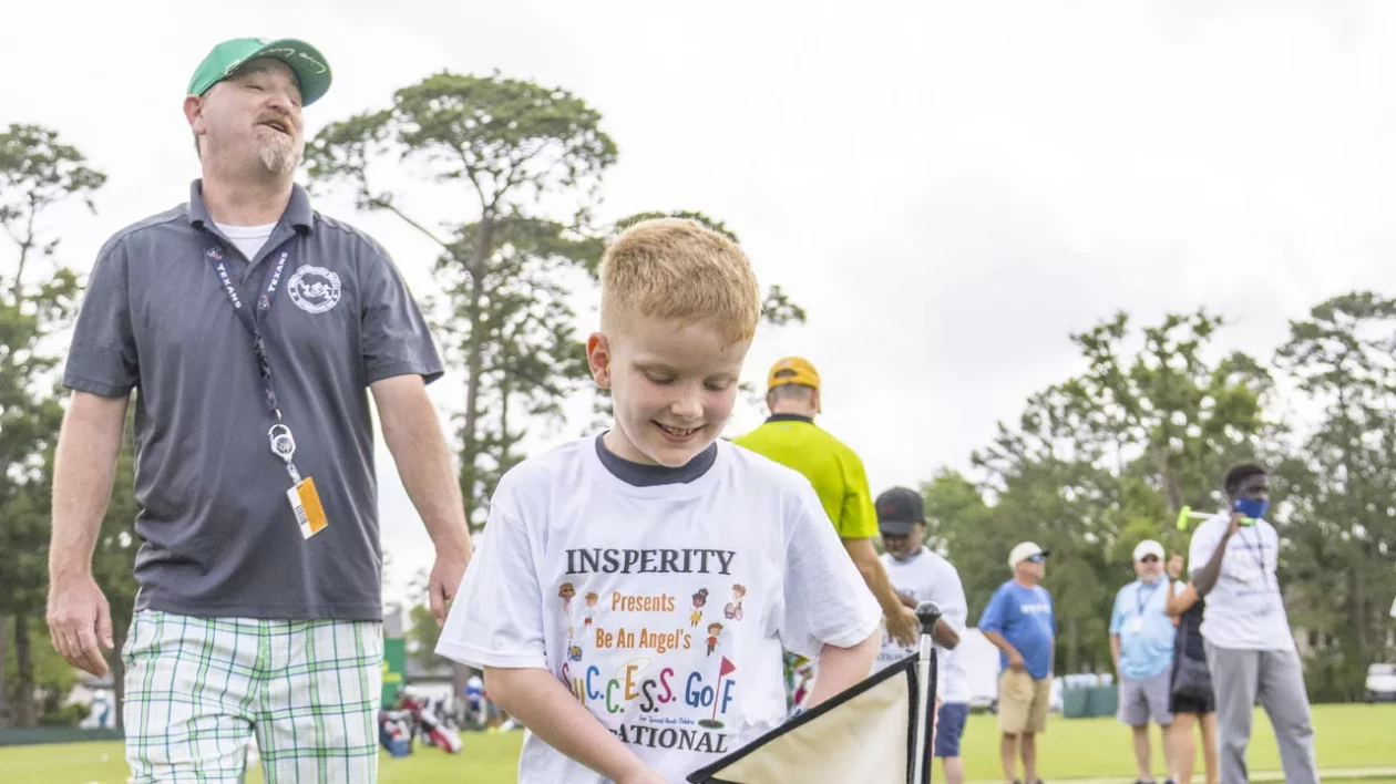 young boy smiling with an Insperity Invitational t-shirt