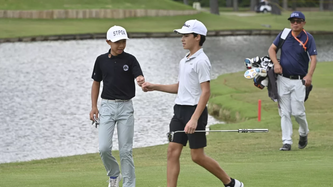 young golfers give a fist bump to each other on the way to the green